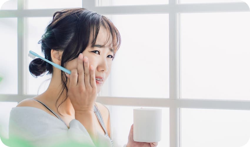 頬を抑えている女性