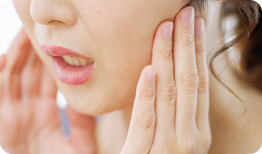 頬を抑えている写真